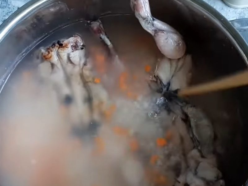 Cháo nấu mềm thì cho cà rốt và thịt ếch vào
