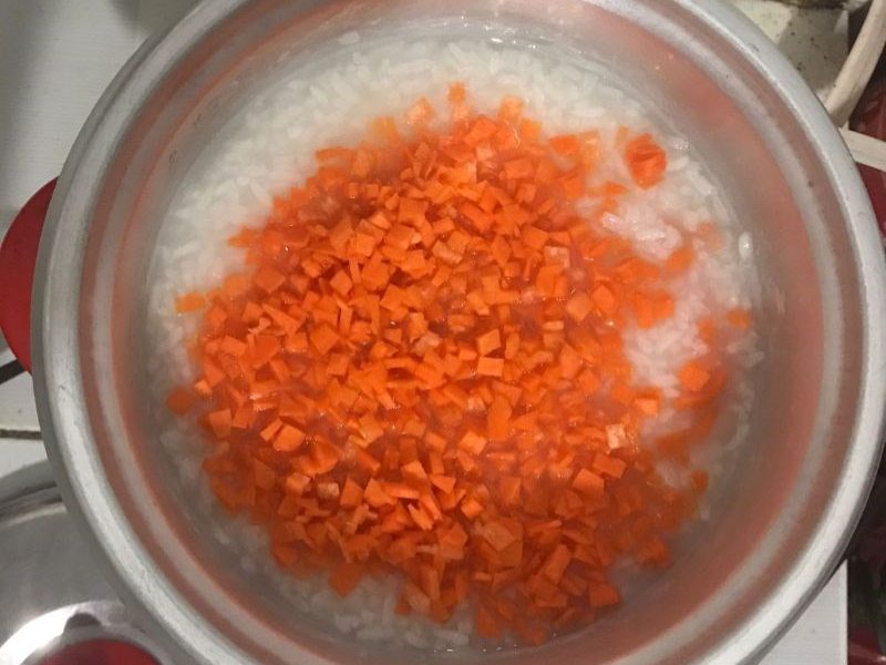 Cho cơm nguội vào nồi nấu sôi rồi cho cà rốt vào