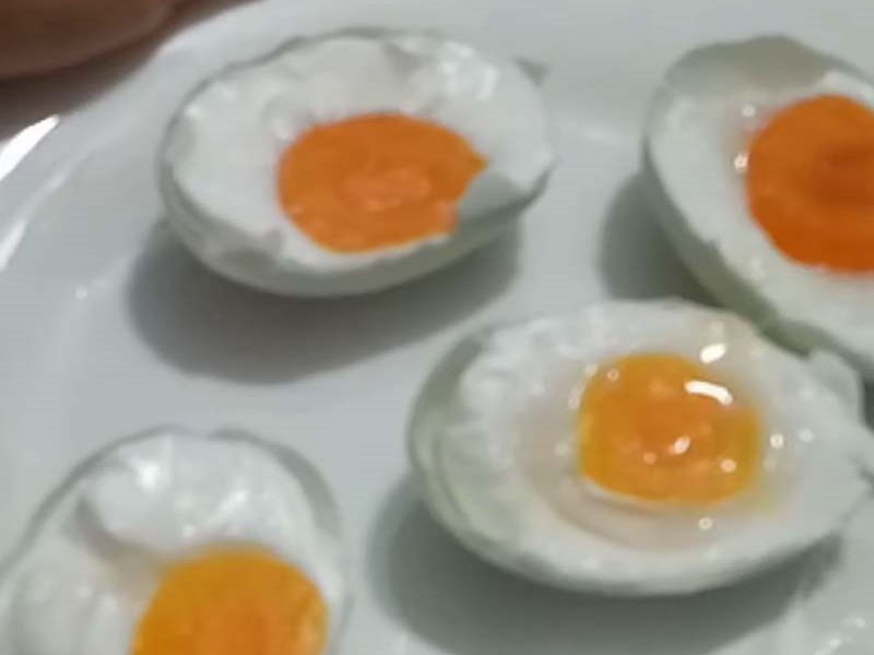 Cắt đôi quả trứng rồi xếp ra đĩa ăn kèm cháo 